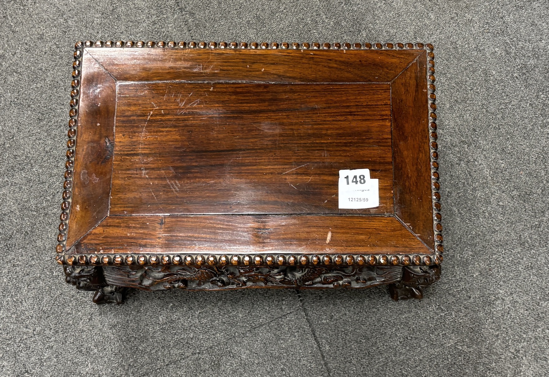 A Chinese low rectangular hardwood stand carved with dragons, width 39cm, depth 25cm, height 21cm
